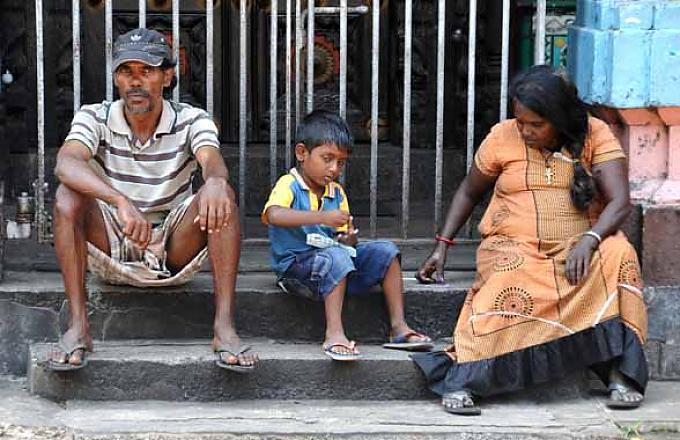 Eine Familie sitzt auf den Stufen des Old-Kathiresan-Tempel Wolfendhal-Kirche in der Pettah