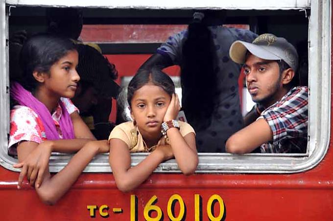 Dicht gedrängt sitzen die Passagiere in dem Zug. Buddha-Statue in Kandy.