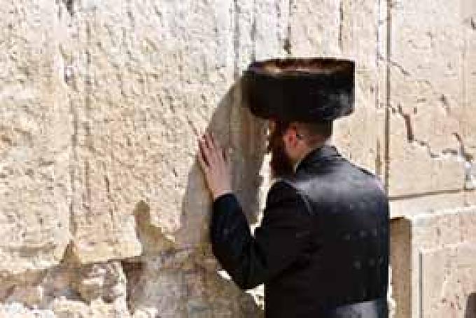 Betender mit Schtreimel-Mützen aus dem Pelz von Zobeln, Mardern oder Füchsen. 18 Meter hoch erhebt sich die alte Steinmauer mit den großen Sandsteinquadern über die leise murmelnden Betenden.